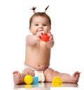 Infant child baby toddler sitting in diaper with yellow blue and red educational toys playing isolated Royalty Free Stock Photo