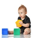 Infant child baby toddler sitting in dress with green blue and yellow brick toy playing isolated on a white Royalty Free Stock Photo