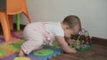 Infant, childhood concept - happy funny toddler kid 8 month baby girl sit lick playing Wooden and Wired Bead Maze Abacus Royalty Free Stock Photo