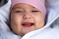 Infant, childhood, emotion concept - close-up of cute smiling portrait face of brown-eyed chubby newborn awake toothless Royalty Free Stock Photo