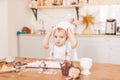 Infant cook baby portrait wearing apron and chef hat testing