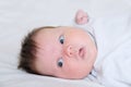 Infant cute baby awaken portrait lying on white sheets Royalty Free Stock Photo