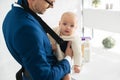 infant daughter in babycarrier with father