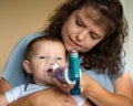 Infant getting breathing treatment from mother