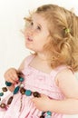 Infant girl holding a large bead necklace. Royalty Free Stock Photo