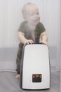 Infant kid and humidifier. Steam closes boy`s face Royalty Free Stock Photo