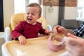 Infant little baby girl crying and don't want to eat food from her father. Royalty Free Stock Photo