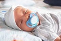 Infant newborn baby boy sleeping peacefully with pacifier on the bed Royalty Free Stock Photo
