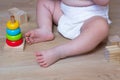 Infant playing with Ecological toys made from natural material. Kids Wooden Blocks and baby pyramid