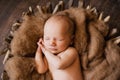 2. An infant sleeping with her hands under her cheeks at a newborn photoshoot