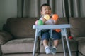 Infants are playing ball happily inside the house.