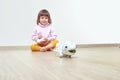 Infatuated cute little girl playing plastic toy lizard robot with a remote control. The nano-toy chameleon, modern technology of Royalty Free Stock Photo