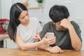 Infidelity, suspicion asian young couple love fight relationship, wife holding cellphone, smartphone cheating on phone, scolding Royalty Free Stock Photo