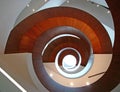 Concept of infinity. Multistory indoor atrium with suspended wood spiral stairs belly like camera shutter at USYD Business School