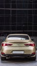 Infiniti Q60 coupe car, rear view. Goldish premium sports coupe with V6 engine