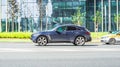 Infiniti QX70 is accelerating on highway on city buildings background