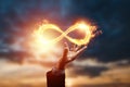 Infinity fire sign over hand of businessman on sunset background