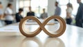 Infinity loop symbol made of cardboard on office table with blurred team in background, representing sustainability, business Royalty Free Stock Photo