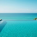 Infinity pool with clear, turquoise water seamlessly merging with the ocean in the Royalty Free Stock Photo