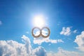 infinity sign, with sun and clouds, on a clear blue sky