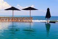 Infinity swimming pool with beach bar count, umbrellas and lounges Royalty Free Stock Photo