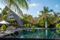 Infinity swimming pool near ocean and tropical beach view at island luxury resort Royalty Free Stock Photo