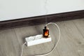 Inflamed plug in power strip indoors. Electrical short circuit