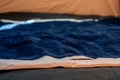 Selective focus of an inflatable air mattress on the floor of a tent being filled up.