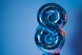 Inflatable ball eight in neon light holds a boy