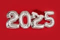 2025 inflatable balloons on red background Santa hat twenty twenty five