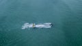 Inflatable banana boat with tourists in blue calm sea. Group of people riding banana boat. Speeding away