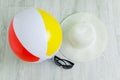 Inflatable bathing ball, straw hat sunglasses. White wooden background Royalty Free Stock Photo