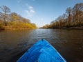 An inflatable blue kayak floats on the river at sunset. View of the bow of the boat Royalty Free Stock Photo