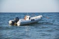 An inflatable boat with an engine in the sea at sunset. Royalty Free Stock Photo