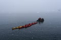 Inflatable boat full of tourists towing red and yellow sea kayaks in Paradise Bay, Antarctica Royalty Free Stock Photo