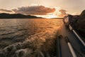 an inflatable boat with a motor rushes along the waves of the Volga river towards the sunset against