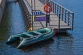 Inflatable boat and red life buoy on a wooden boat pier by the sea Royalty Free Stock Photo