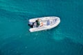 An inflatable boat slowly with a motor floats on the azure sea. Boat trip on a sunny summer day