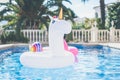 Inflatable colorful white unicorn and pink flamingo at the swim pool. Vacation week in the swimming pool with plastic