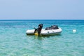 Inflatable dinghy boat with outboard motor moored in tropical sea Royalty Free Stock Photo