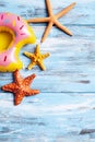 Inflatable donut and starfishes on a blue wooden surface