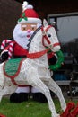 Inflatable snowmen with reindeer in foreground to celebrate Christmas, photographed in a suburban garden in Windsor UK.