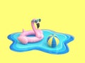 Inflatable flamingo and beach ball floating on the surface of blue water Royalty Free Stock Photo