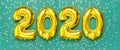 2020 inflatable golden numbers with confetti in the shape of stars on green background. New year winter decoration, holiday symbol