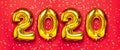 2020 inflatable golden numbers with confetti in the shape of stars on red background. New year winter decoration, holiday symbol.