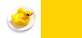 Inflatable mini yellow chicken or duckling on white plate on white background. Creative food concept, tobacco chicken. Flat lay