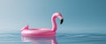 Inflatable pink flamingo float on calm blue water surface with reflections and ripples Copy Space. Royalty Free Stock Photo