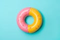 Inflatable pink and yellow donut ring floating on a blue background. Generative AI illustration