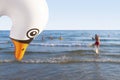 Inflatable plastic swan spies on people on a busy beach