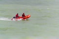 An inflatable rescue boat with surf lifesavers patrolling the beach at Eastbourne UK, August 2019